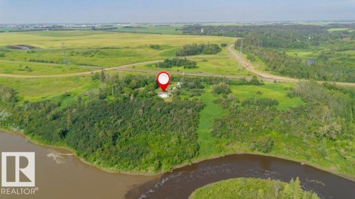 Rural property featuring a riverfront setting, expansive green fields, and surrounding woodland - 55319 Rge Road 222, Rural Sturgeon County, AB 