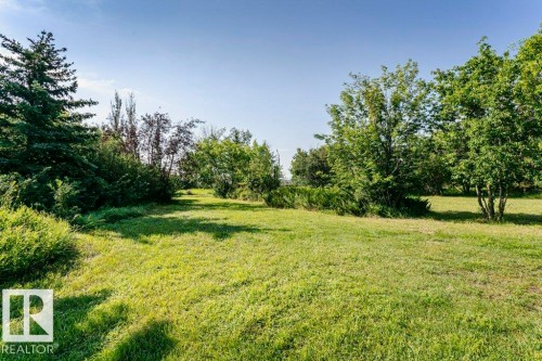 Expansive green lawn surrounded by mature trees and varied shrubbery - 55319 Rge Road 222, Rural Sturgeon County, AB 