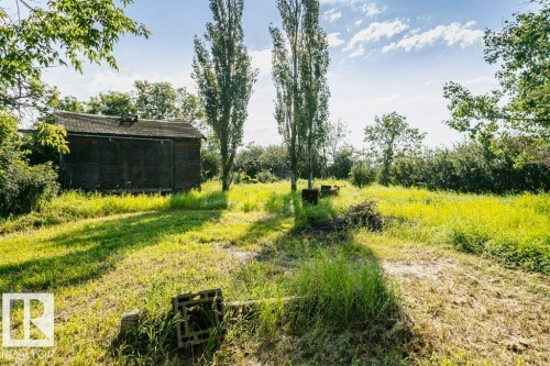Expansive property with a rustic outbuilding featuring a wooden exterior and a shingled roof - 55319 Rge Road 222, Rural Sturgeon County, AB 