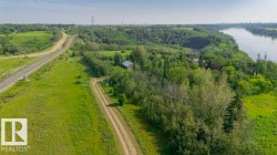 Expansive green landscape featuring a prominent river, dense wooded areas, and a visible railway line - 