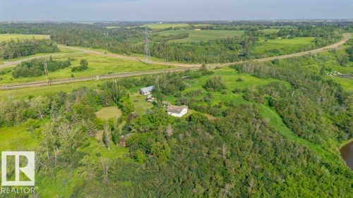 Expansive property featuring a white residence situated on a sloped, tree-covered landscape - 55319 Rge Road 222, Rural Sturgeon County, AB 