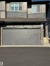 Exterior featuring a two-car garage, stone veneer accents, horizontal siding, and multiple windows - #2 2710 66 St Sw, Edmonton, AB  - Outdoor 