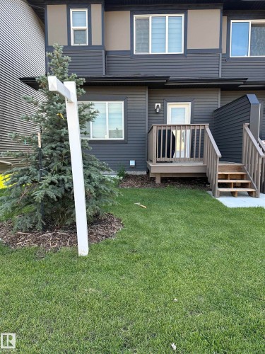 Rear exterior featuring horizontal siding in a dark tone with lighter accent panels - #2 2710 66 St Sw, Edmonton, AB - Outdoor With Deck Patio Veranda