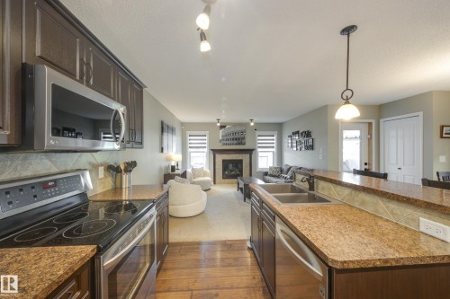 5881 168A Avenue Nw, Edmonton, AB - Indoor Photo Showing Kitchen With Fireplace With Double Sink