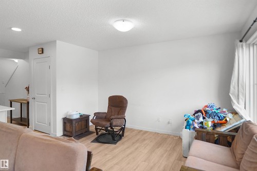 Open-concept room featuring light wood-finish flooring, white walls, and a ceiling-mounted light fixture - #42 19904 31 Av Nw, Edmonton, AB - Indoor