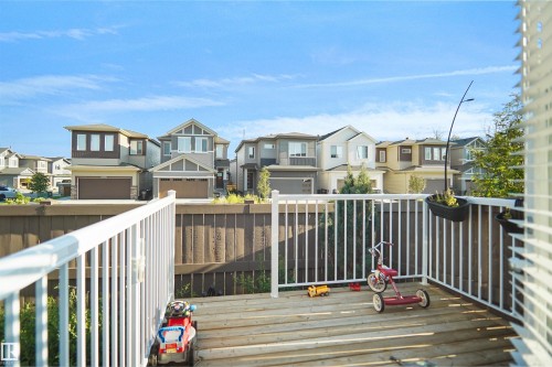 Exterior deck with white railing, featuring wood decking and a privacy fence - #42 19904 31 Av Nw, Edmonton, AB - Outdoor