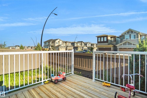 Wood-finish deck with white railings, offering outdoor living space - #42 19904 31 Av Nw, Edmonton, AB - Outdoor With Deck Patio Veranda