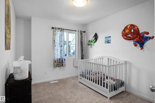 Carpeted room with a ceiling-mounted light fixture, a window with drapery rods, and a door - #42 19904 31 Av Nw, Edmonton, AB - Indoor Photo Showing Bedroom