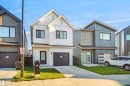 Contemporary two-story residence featuring white vertical siding and dark trim - #42 19904 31 Av Nw, Edmonton, AB  - Outdoor With Facade 