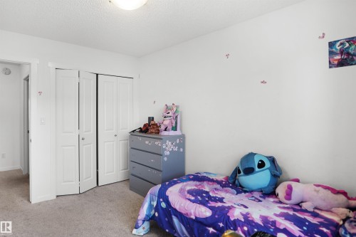 Bedroom featuring neutral carpeting, white walls, and a bi-fold closet door - #42 19904 31 Av Nw, Edmonton, AB - Indoor Photo Showing Bedroom