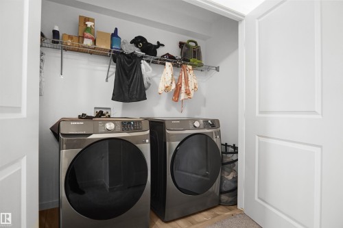 Dedicated laundry area featuring a wire shelving system and wood-finish flooring - #42 19904 31 Av Nw, Edmonton, AB - Indoor Photo Showing Laundry Room