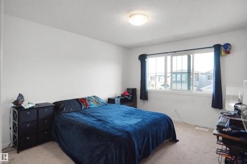Neutral wall color with textured ceiling and a flush-mount light fixture - #42 19904 31 Av Nw, Edmonton, AB - Indoor Photo Showing Bedroom