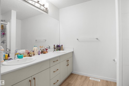 Double vanity with integrated sinks and white countertops - #42 19904 31 Av Nw, Edmonton, AB - Indoor Photo Showing Bathroom