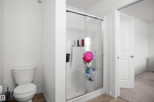 Modern shower enclosure with sliding glass door and integrated shelving - #42 19904 31 Av Nw, Edmonton, AB - Indoor Photo Showing Bathroom