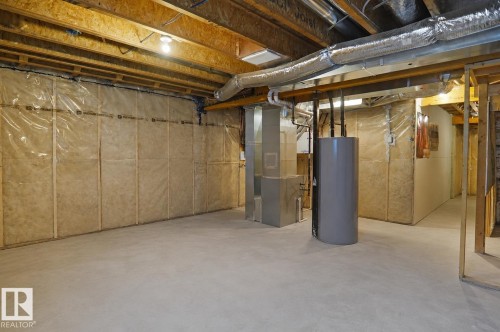 Unfinished lower level featuring exposed wood joists, concrete flooring, and insulated perimeter walls - #42 19904 31 Av Nw, Edmonton, AB - Indoor Photo Showing Basement