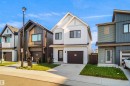 Modern white-sided home featuring a dark brown garage door and matching front door - #42 19904 31 Av Nw, Edmonton, AB  - Outdoor With Facade 