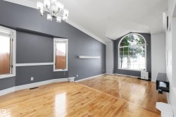 Interior space featuring polished wood-finish flooring and a contemporary chandelier - 