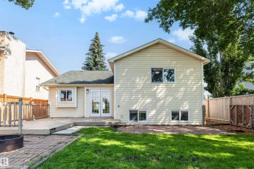 Rear exterior featuring light-colored siding, a dark shingle roof, and multiple windows - 4639 10 Avenue Nw, Edmonton, AB - Outdoor With Exterior