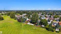 Expansive green space bordering a residential neighborhood, featuring mature trees and established homes - 