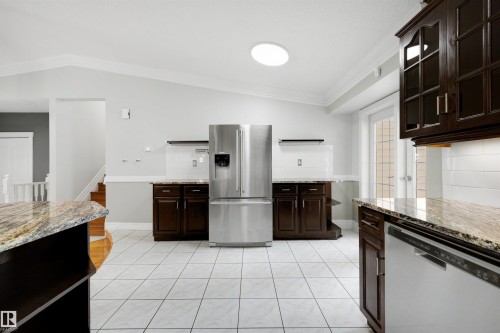 Kitchen featuring white tile flooring and dark wood cabinetry - 4639 10 Avenue Nw, Edmonton, AB - Indoor Photo Showing Kitchen