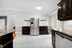 Kitchen featuring white tile flooring and dark wood cabinetry - 