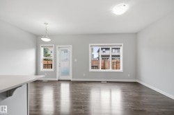 Expansive room featuring wood-finish flooring, light gray wall paint, and white trim - 