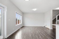 Spacious room featuring wood-finish flooring, light gray walls, and white trim - 