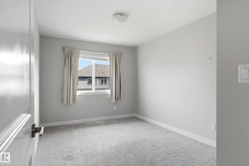 Bright room featuring soft gray walls and light gray carpeting - 1860 Keene Crescent Sw, Edmonton, AB - Indoor Photo Showing Other Room