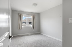 Bright room featuring soft gray walls and light gray carpeting - 