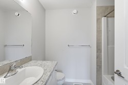 Bathroom featuring a vanity with an undermount sink, a chrome faucet, and a light-toned countertop - 