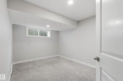 Room with light gray wall paint, gray carpeting, a window with horizontal blinds, and recessed ceiling lighting - 