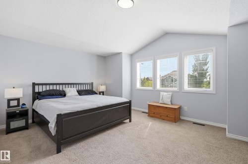 Carpeted room featuring a vaulted ceiling and three large windows with white blinds - 3606 Whitelaw Bay Nw, Edmonton, AB - Indoor Photo Showing Bedroom