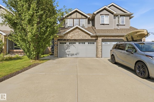 Contemporary two-story residence featuring a stone and siding facade, twin garage doors, and a concrete driveway - 3606 Whitelaw Bay Nw, Edmonton, AB - Outdoor With Facade