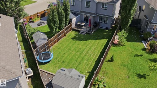 Expansive fenced backyard featuring a large grass area, a wood deck, and a shed - 3606 Whitelaw Bay Nw, Edmonton, AB - Outdoor With Deck Patio Veranda