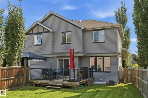 Expansive backyard featuring a manicured lawn, a multi-level deck with black railing, and a private wooden fence - 3606 Whitelaw Bay Nw, Edmonton, AB - Outdoor With Deck Patio Veranda