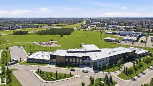 Expansive green spaces surround a contemporary commercial structure with a large parking area - 3606 Whitelaw Bay Nw, Edmonton, AB - Outdoor With View