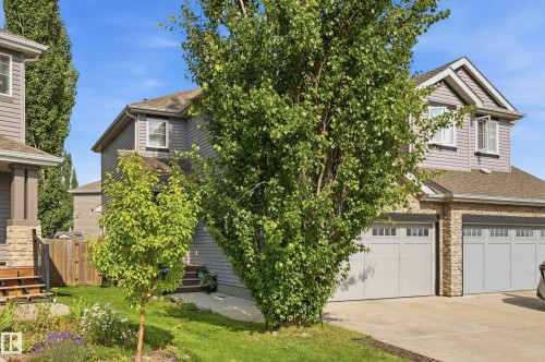 Two-story residence featuring grey siding and a stone-clad garage facade - 3606 Whitelaw Bay Nw, Edmonton, AB - Outdoor
