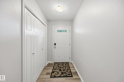 Entryway featuring a white paneled door with glass insert, wood-finish flooring, and light gray walls - 3606 Whitelaw Bay Nw, Edmonton, AB - Indoor Photo Showing Other Room