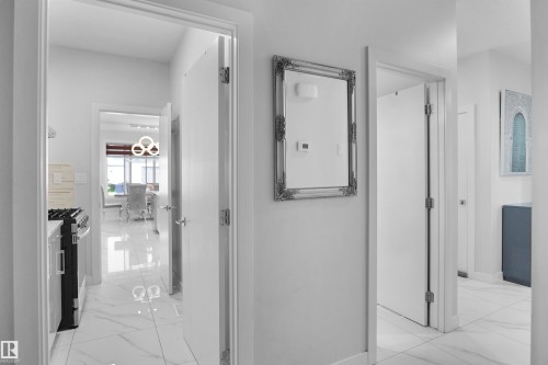 Hallway featuring white doors with brushed nickel hardware, white walls, and polished tile flooring - 4003 39 Street, Beaumont, AB - Indoor Photo Showing Other Room