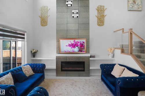 Living area featuring a floor-to-ceiling tiled fireplace surround with an integrated electric fireplace - 4003 39 Street, Beaumont, AB - Indoor Photo Showing Living Room With Fireplace