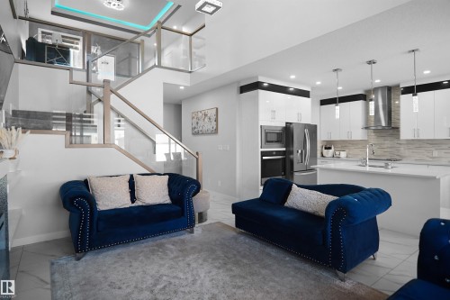 Open-concept living space featuring a modern kitchen and staircase - 4003 39 Street, Beaumont, AB - Indoor