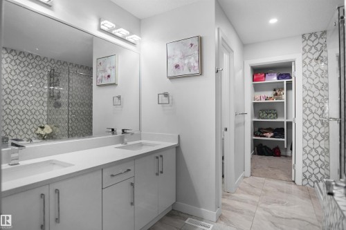 Double vanity with white cabinetry and integrated sinks - 4003 39 Street, Beaumont, AB - Indoor Photo Showing Bathroom