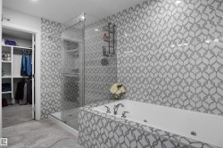Contemporary bathroom featuring a jetted soaking tub, glass-enclosed shower, patterned wall tile, and large format floor tile - 