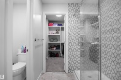 Glass-enclosed shower featuring a patterned tile surround - 