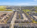Aerial perspective showcasing a residential community with numerous single-family homes, clear skies, and multiple ponds - 4003 39 Street, Beaumont, AB  - Outdoor With View 
