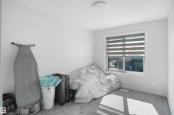 Recessed window with layered horizontal blinds, flush-mount ceiling light fixture, and light gray carpeted flooring - 