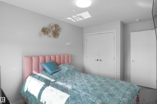 Neutral-toned bedroom featuring light gray walls, white trim, and a white ceiling with a flush-mount light fixture - 4003 39 Street, Beaumont, AB - Indoor Photo Showing Bedroom