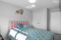 Neutral-toned bedroom featuring light gray walls, white trim, and a white ceiling with a flush-mount light fixture - 
