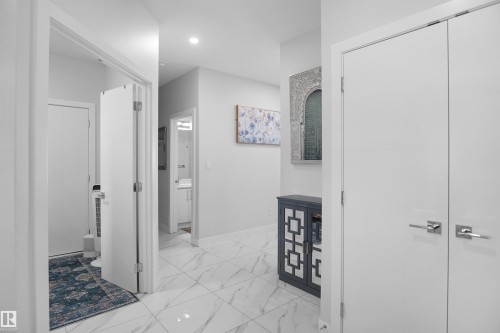 Bright interior hallway with recessed lighting and polished tile flooring - 4003 39 Street, Beaumont, AB - Indoor Photo Showing Other Room