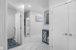 Bright interior hallway with recessed lighting and polished tile flooring - 